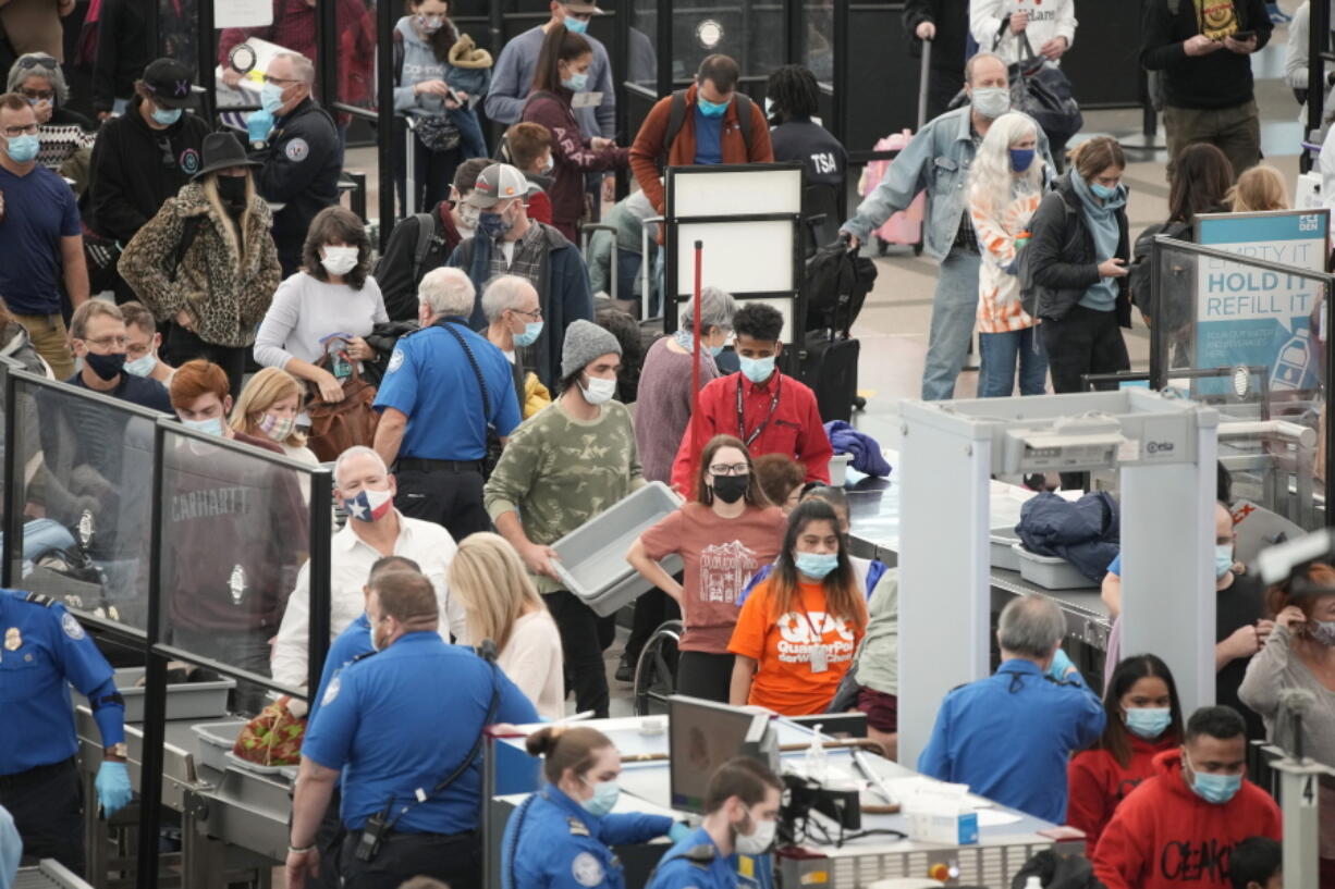 Travelers queue up at the south security checkpoint as traffic increases with the approach of the Thanksgiving Day holiday Tuesday, Nov. 23, 2021, at Denver International Airport in Denver.