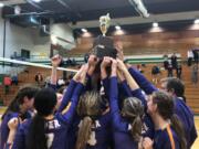 The Columbia River volleyball team hoists the district championship trophy after beating Ridgefield in five sets on Saturday at Tumwater High School.