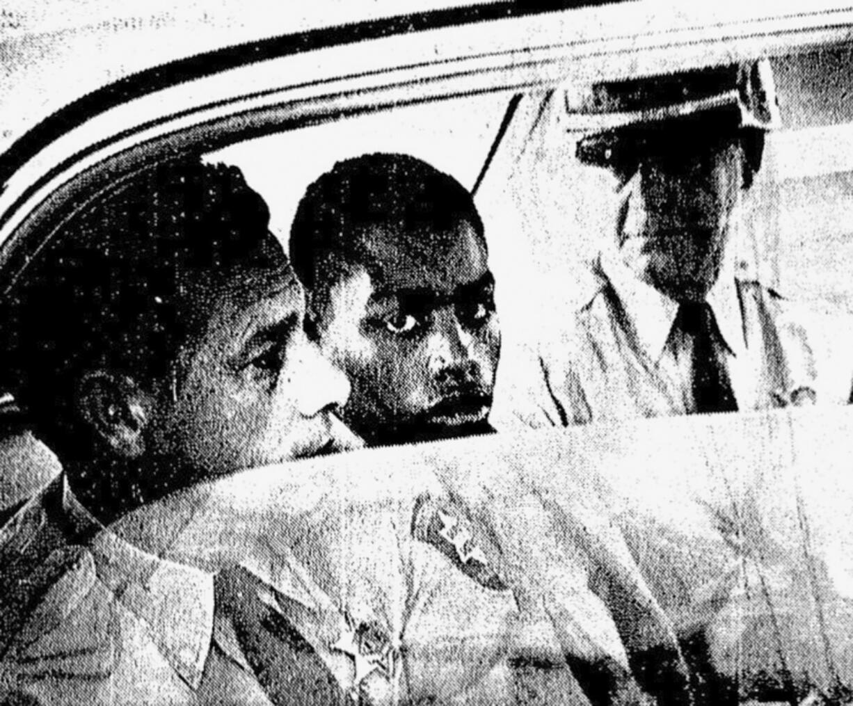 FILE - In this February 1964 photo, Henry Montgomery, flanked by two deputies, awaits the verdict in his trial for the murder of Deputy Sheriff Charles H. Hurt in Louisiana. On Wednesday, Nov. 17, 2021, a Louisiana parole board votes for the third time whether to grant Montgomery parole. Montgomery's supporters say he's fully reformed and deserves to be freed.