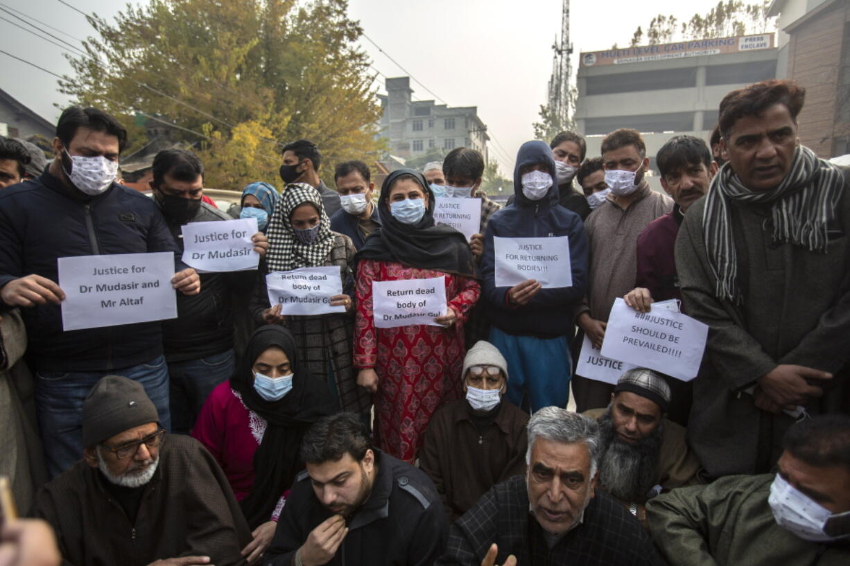 Family members and friends of two civilians who were killed in a gunfight, hold placards during a protest, in Srinagar, Indian controlled Kashmir, Wednesday, Nov 17, 2021. Dozens of relatives of two civilians killed in a controversial gunfight in Indian-controlled Kashmir staged a protest in the disputed region's main city on Wednesday, pleading authorities to return the bodies of the slain so that they could bury them as per their wishes.