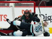 Seattle Kraken right wing Jordan Eberle, right, falls to the ice over Arizona Coyotes goalie Scott Wedgewood, left, during the first period of an NHL hockey game Saturday, Nov. 6, 2021, in Glendale, Ariz. (AP Photo/Ross D.