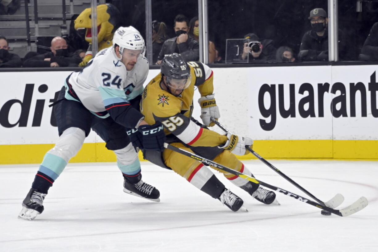 Vegas Golden Knights right wing Keegan Kolesar (55) drives the puck against Seattle Kraken defenseman Jamie Oleksiak (24) during the second period of an NHL hockey game Tuesday, Nov. 9, 2021, in Las Vegas.