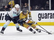 Vegas Golden Knights right wing Keegan Kolesar (55) drives the puck against Seattle Kraken defenseman Jamie Oleksiak (24) during the second period of an NHL hockey game Tuesday, Nov. 9, 2021, in Las Vegas.