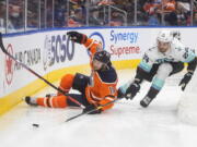 Seattle Kraken's Jamie Oleksiak (24) and Edmonton Oilers' Zach Hyman (18) battle for the puck during the second period of an NHL hockey game, Monday, Nov. 1, 2021 in Edmonton, Alberta.