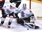 Seattle Kraken goaltender Chris Driedger (60) makes a save against the Florida Panthers next to defenseman Haydn Fleury (4) during the second period of an NHL hockey game Saturday, Nov. 27, 2021, in Sunrise, Fla.