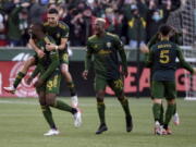 Portland Timbers defender Larrys Mabiala, left, is mobbed by teammates after scoring a goal during the first half of an MLS soccer match against the Minnesota United in Portland, Ore., Sunday, Nov. 21, 2021.