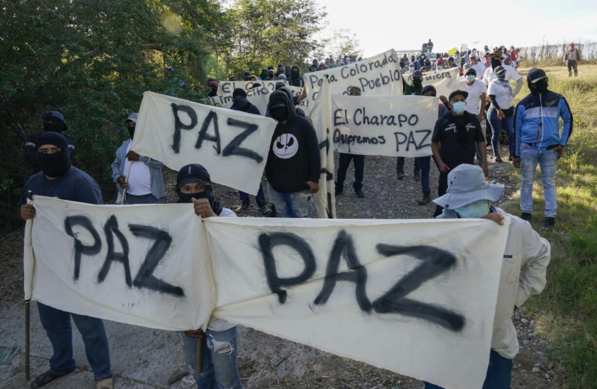 Residents of Aguililla and other nearby communities who are fed up with the army's strategy of simply separating the Jalisco and the Michoacan-based Viagras gangs, march against roadblocks in Loma Blanca, Mexico, Tuesday, Nov. 16, 2021. The army policy effectively allows the Viagras, best known for kidnapping and extorting money, to set up roadblocks and checkpoints that have choked off all commerce with Aguililla. Limes and cattle heading out, or supplies heading in, must pay a war tax to the Viagras.