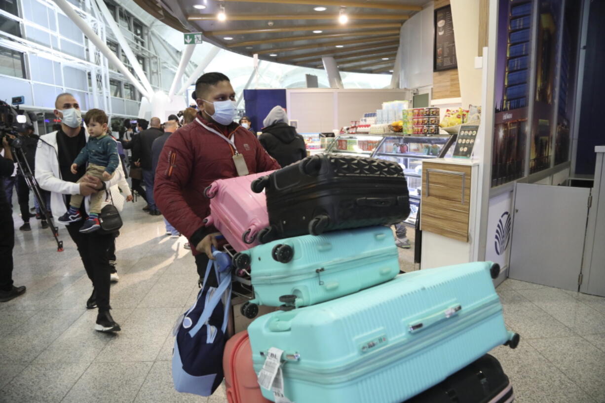 Iraqi migrants arrive at the airport in Irbil, Iraq, on Thursday. Hundreds of Iraqis were flown home from Belarus after abandoning their hopes of reaching the European Union.