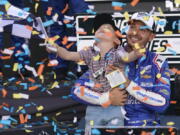 Kyle Larson, right, and his son Owen celebrate after winning a NASCAR Cup Series championship on Sunday in Avondale, Ariz.