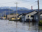 Floodwater inundates homes along a road Wednesday, Nov. 17, 2021, in Sumas, Wash. An atmospheric river--a huge plume of moisture extending over the Pacific and into Washington and Oregon--caused heavy rainfall in recent days, bringing major flooding in the area.