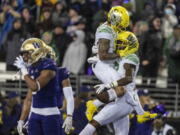 Oregon wide receiver Mycah Pittman, left, and wide receiver Devon Williams, right, celebrate a touchdown reception by Williams during the first half of a NCAA college football game against Washington, Saturday, Nov. 6, 2021, in Seattle.