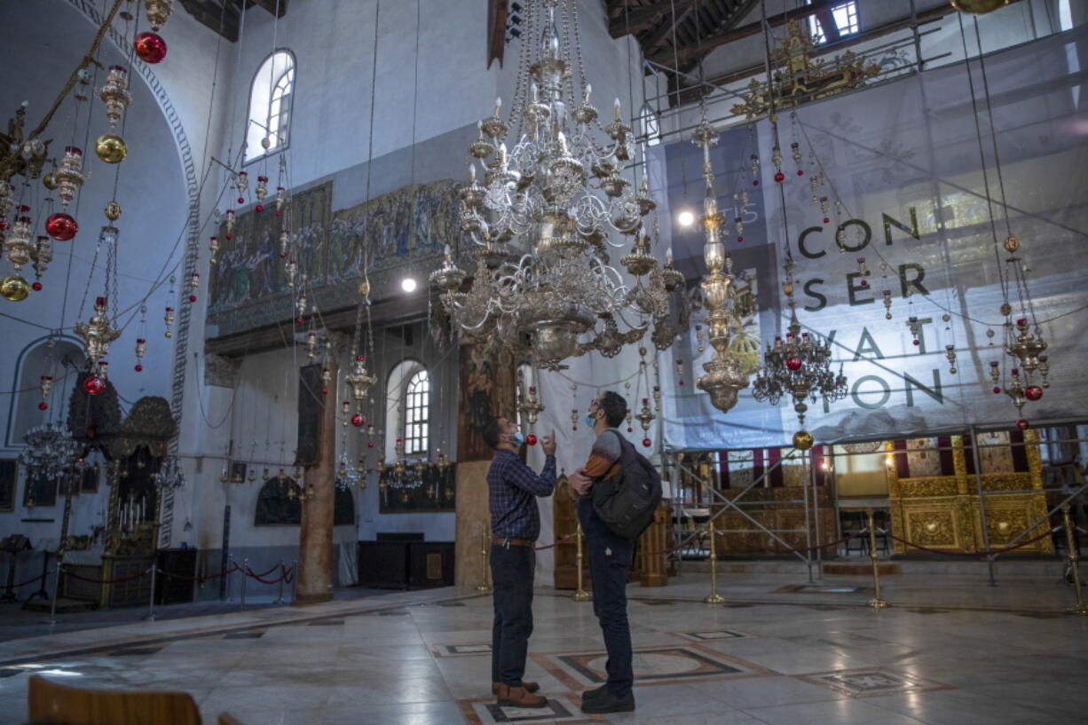 Tourists visit the Church of the Nativity, in the West Bank city of Bethlehem, Tuesday, Nov. 16, 2021. The Church of the Nativity, built on the spot where Christians believe Jesus was born, is wrapping up a three-year restoration project just in time for the normally busy Christmas season.