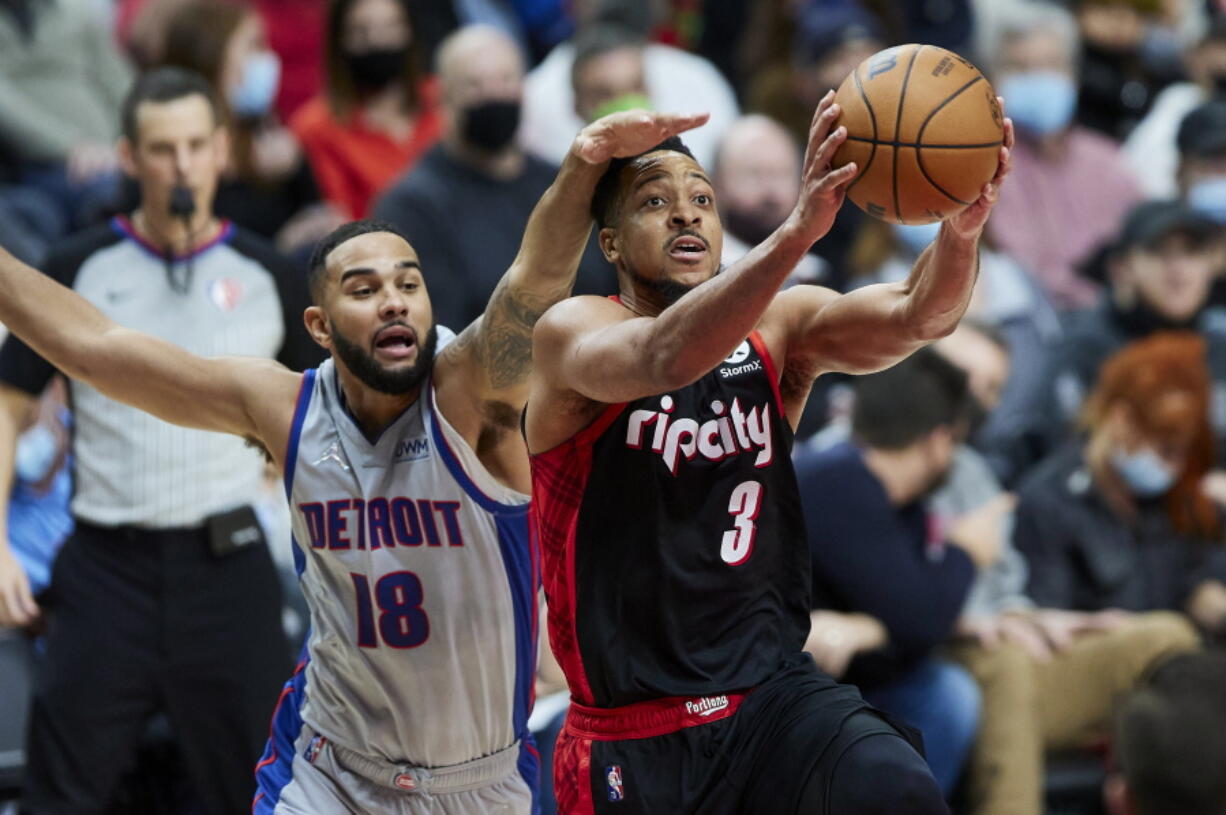 Portland Trail Blazers guard CJ McCollum, right, is fouled by Detroit Pistons guard Cory Joseph during the second half of an NBA basketball game in Portland, Ore., Tuesday, Nov. 30, 2021.