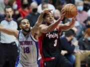 Portland Trail Blazers guard CJ McCollum, right, is fouled by Detroit Pistons guard Cory Joseph during the second half of an NBA basketball game in Portland, Ore., Tuesday, Nov. 30, 2021.