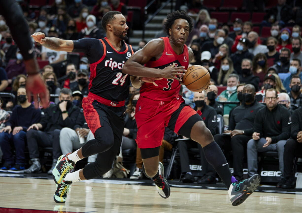 Toronto Raptors forward OG Anunoby, right, drives to the basket as Portland Trail Blazers forward Norman Powell defends during the first half of an NBA basketball game in Portland, Ore., Monday, Nov. 15, 2021.