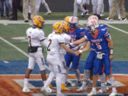 Ridgeifeld captains Ty Snider (5), Wyatt Bartroff, Matt Kinswa and Connor Delamarter shake handes with Aberdeen’s Toby Heggie (2), Drew Lock (3) and Isiah Watson after the coin toss before Saturday’s Class 2A district playoff game at Ridgefield (Tim Martinez/The Columbian)