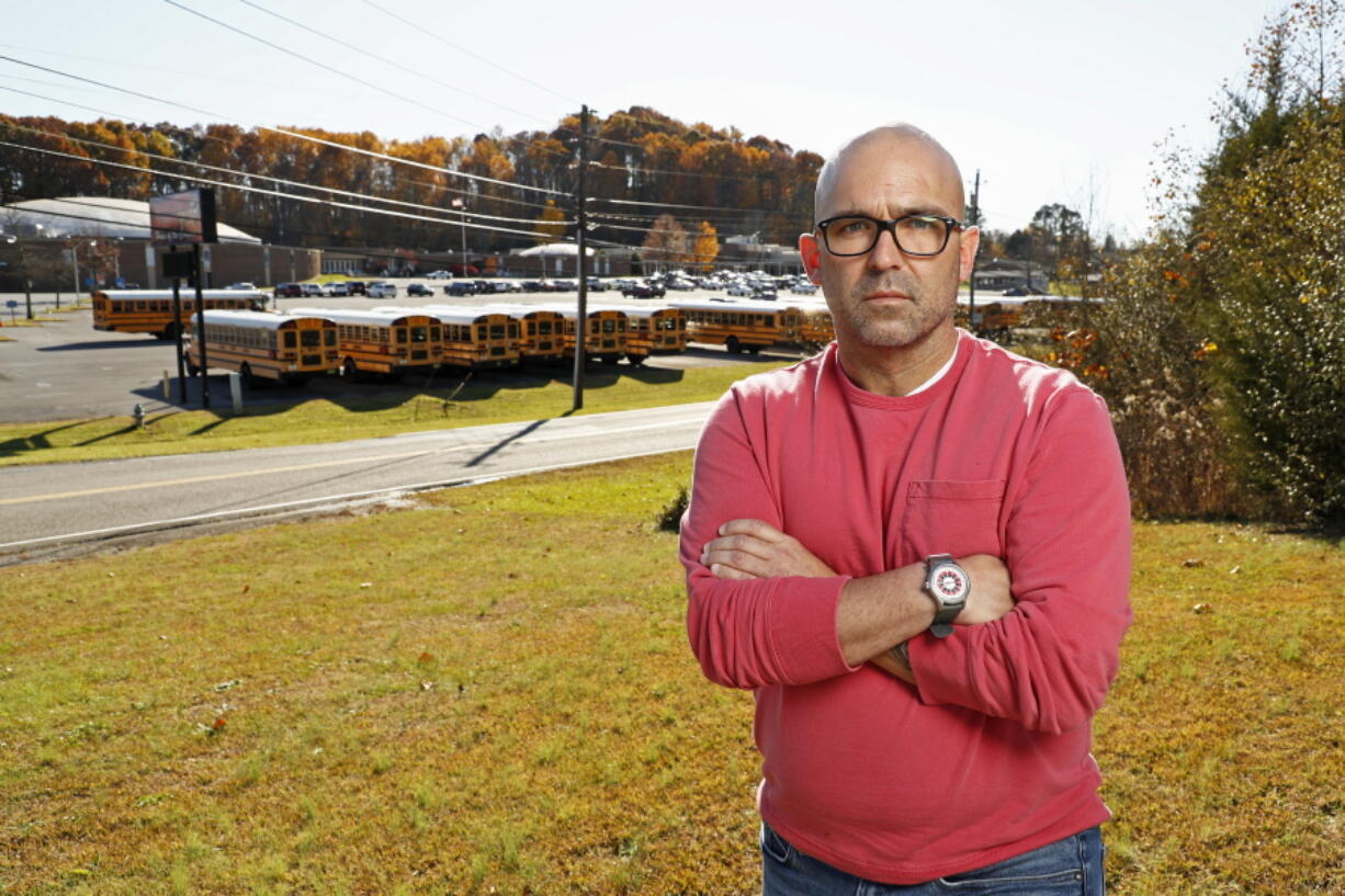 Matt Hawn stands across the street from the former Sullivan Central High School Nov. 12, 2021, in Kingsport, Tenn. Hawn was fired from the school after school officials said he used materials with offensive language and failed to provide a conservative viewpoint during discussions of white privilege in his contemporary issues class, which has since been eliminated.