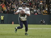 Seattle Seahawks' Russell Wilson scrambles during the second half of an NFL football game against the Green Bay Packers Sunday, Nov. 14, 2021, in Green Bay, Wis.