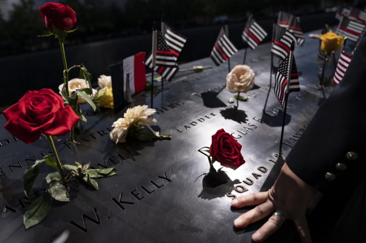 FILE - A firefighter places his hand on the name engravings on the south pool during ceremonies to commemorate the 20th anniversary of the Sept. 11 terrorist attacks, Sept. 11, 2021, at the National September 11 Memorial & Museum in New York. The FBI released hundreds of pages of newly declassified documents Wednesday, Nov. 3, about its long effort to explore connections between the Saudi government and the Sept. 11 attacks, revealing the scope of a strenuous but ultimately fruitless investigation whose outcome many question to this day.