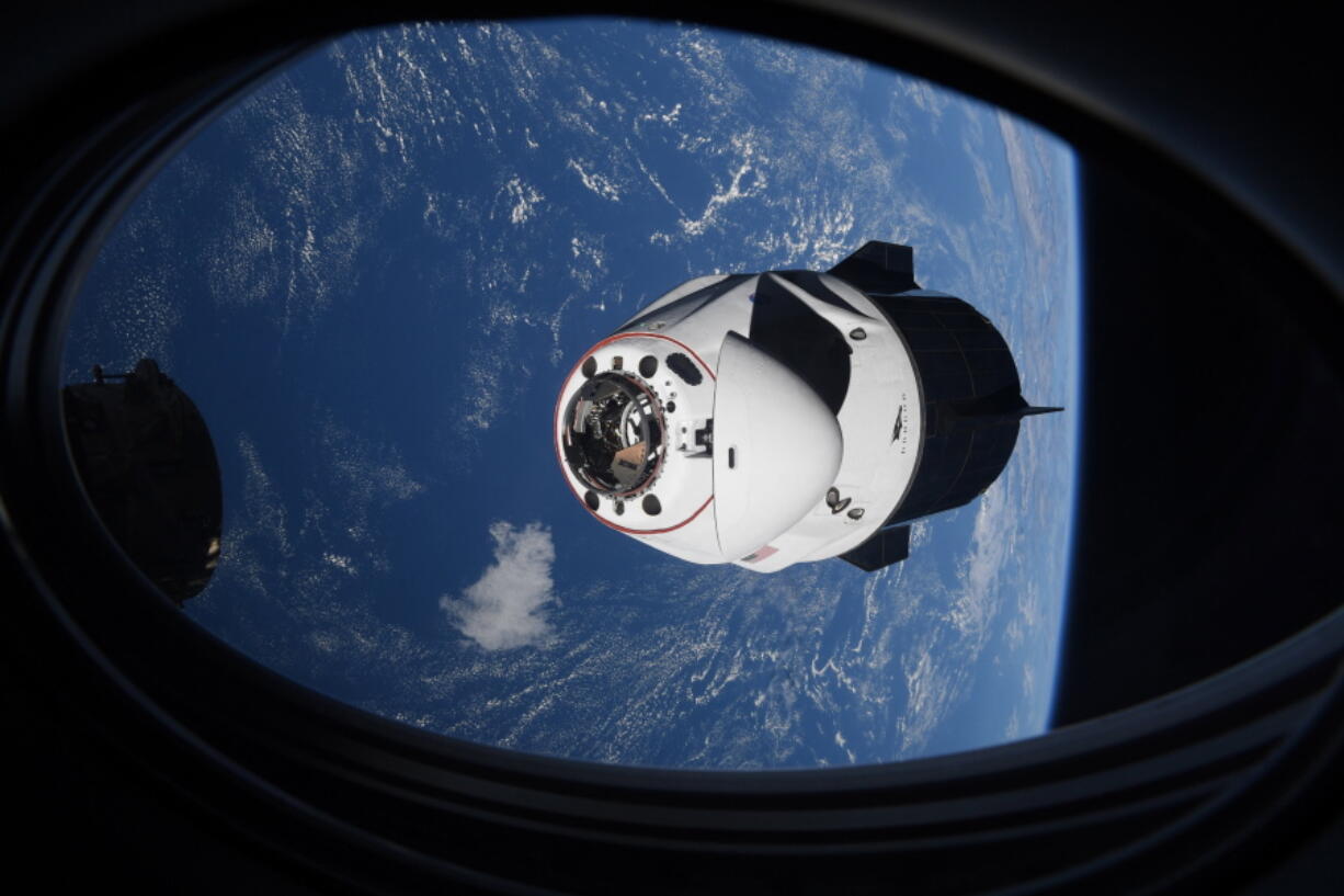 FILE - In this April 24, 2021 file photo made available by NASA, the SpaceX Crew Dragon capsule approaches the International Space Station for docking. Space junk is threatening the seven astronauts aboard the International Space Station and forcing them to seek shelter in their docked capsules. The U.S. Space Command says it's tracking a field of orbiting debris, the apparent result of some satellite break-up event. The astronauts retreated into their docked capsules on Monday, Nov. 15, 2021 after being informed of the threat.