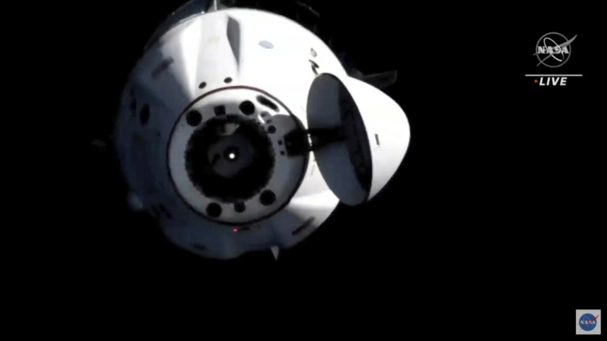 In this image from video provided by NASA, astronauts in the SpaceX Dragon capsule undock from the International Space Station on Monday, Nov.