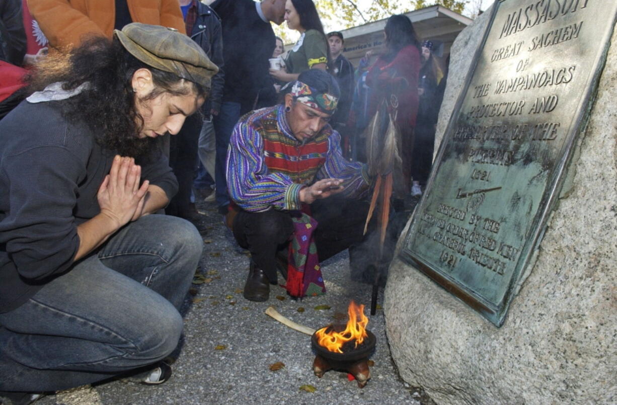 FILE- Supporters of Native Americans pause following a prayer during the 38th National Day of Mourning at Coles Hill in Plymouth, Mass., on Nov. 22, 2007. Denouncing centuries of racism and mistreatment of Indigenous people, members of Native American tribes from around New England will gather on Thanksgiving 2021 for a solemn National Day of Mourning observance.