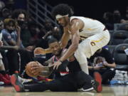 Portland Trail Blazers' Damian Lillard, bottom, looks to pass the ball as Cleveland Cavaliers' Jarrett Allen defends during the first half of an NBA basketball game Wednesday, Nov. 3, 2021, in Cleveland.