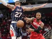 Portland Trail Blazers guard Damian Lillard, right, passes the ball as Houston Rockets center Daniel Theis defends during the first half of an NBA basketball game, Friday, Nov. 12, 2021, in Houston.