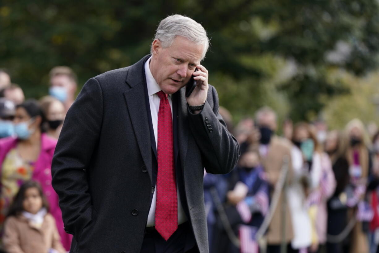 FILE - White House chief of staff Mark Meadows speaks on a phone on the South Lawn of the White House in Washington, on Oct. 30, 2020. At least 13 former Trump administration officials, including Meadows, violated the law by intermingling campaigning with their official government duties. That's according to a new federal investigation released Nov. 9, 2021.