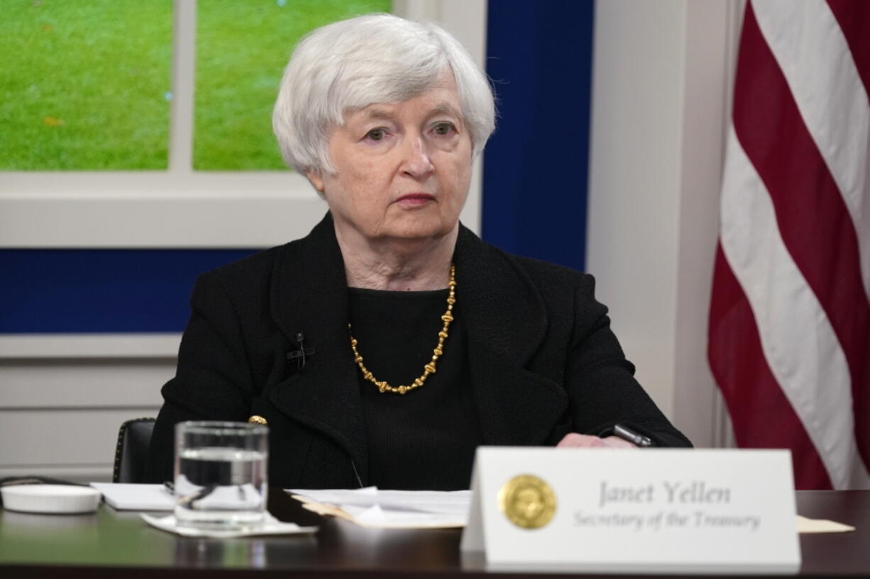 Treasury Secretary Janet Yellen listens as President Joe Biden speaks during a meeting with business leaders about the debt limit in the South Court Auditorium on the White House campus, Wednesday, Oct. 6, 2021, in Washington. The Treasury Department said Wednesday it plans to start scaling back the size of some of its government debt auctions, a sign that the government's huge pandemic-driven borrowing needs are starting to ease.