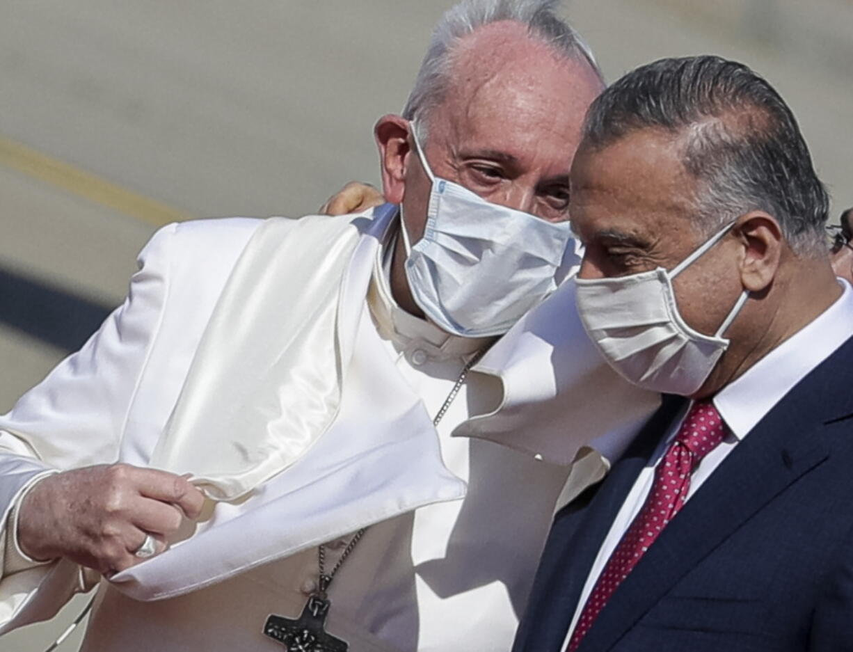 FILE - Pope Francis is greeted by Iraqi Prime Minister Mustafa al-Kadhimi as he arrives at Baghdad's international airport, Iraq, on March 5, 2021. Pope Francis is condemning the assassination attempt against Iraq's prime minister as a "vile act of terrorism" and says he is praying for peace in the country. The Vatican secretary of state, Cardinal Pietro Parolin, sent a telegram Tuesday to Prime Minister Mustafa al-Kadhimi expressing Francis' solidarity and prayers to al-Kadhimi's family and those injured in the drone attack on the prime minister's residence.