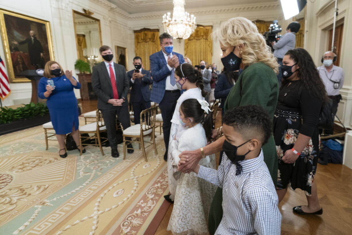 First lady Jill Biden, walks in the East Room with little caregivers, standing in front from left to right, Gabby and Eva Rodriguez, and Mason, during a ceremony at the White House honoring children in military and veteran caregiving families, Wednesday, Nov. 10, 2021.