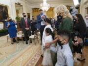 First lady Jill Biden, walks in the East Room with little caregivers, standing in front from left to right, Gabby and Eva Rodriguez, and Mason, during a ceremony at the White House honoring children in military and veteran caregiving families, Wednesday, Nov. 10, 2021.