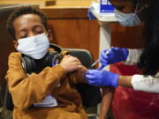 FILE - Cameron West, 9, receives a COVID-19 vaccination at Englewood Health in Englewood, N.J., Monday, Nov. 8, 2021. Health systems have released little data on the racial breakdown of youth vaccinations, and community leaders fear that Black and Latino kids are falling behind.