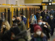 People wear face mask to protect against the coronavirus at the public transport station Friedrichstrasse in Berlin, Germany, Tuesday, Nov. 30, 2021. According to local authorities wearing face masks mandatory in public transport and passengers need to be vaccinated, recovered or tested negative of the coronavirus.