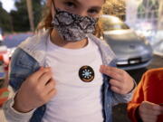 Leah Lefkove, 9, shows off her vaccination sticker just before being the first child to be vaccinated at the Viral Solutions vaccination and testing site in Decatur, Ga., on the first day COVID-19 vaccinations were available for children from 5 to 12 on Wednesday, Nov. 3, 2021. The U.S. enters a new phase Wednesday in its COVID-19 vaccination campaign, with shots now available to millions of elementary-age children in what health officials hailed as a major breakthrough after more than 18 months of illness, hospitalizations, deaths and disrupted education.