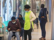 People wait to get vaccinated at a shopping mall, in Johannesburg, South Africa, Friday Nov. 26, 2021. Advisers to the World Health Organization are holding a special session Friday to flesh out information about a worrying new variant of the coronavirus that has emerged in South Africa, though its impact on COVID-19 vaccines may not be known for weeks.