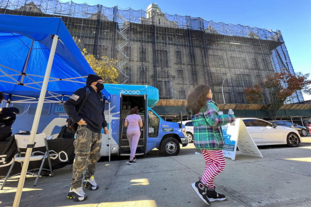 A girl walks outside of a mobile vaccine unit after getting the first dose of her COVID-19 vaccine, outside P.S. 277, Friday, Nov. 5, 2021, in the Bronx borough of New York.