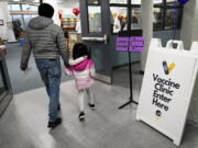 An information sign is displayed as a child arrives with her parent to receive the Pfizer COVID-19 vaccine for children 5 to 11-years-old at London Middle School in Wheeling, Ill., Wednesday, Nov. 17, 2021. (AP Photo/Nam Y.