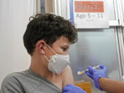 Leo Hahn, 11, gets the first shot of the Pfizer COVID-19 vaccine, Tuesday, Nov. 9, 2021, at the University of Washington Medical Center in Seattle. Last week, U.S. health officials gave the final signoff to Pfizer's kid-size COVID-19 shot, a milestone that opened a major expansion of the nation's vaccination campaign to children as young as 5. (AP Photo/Ted S.