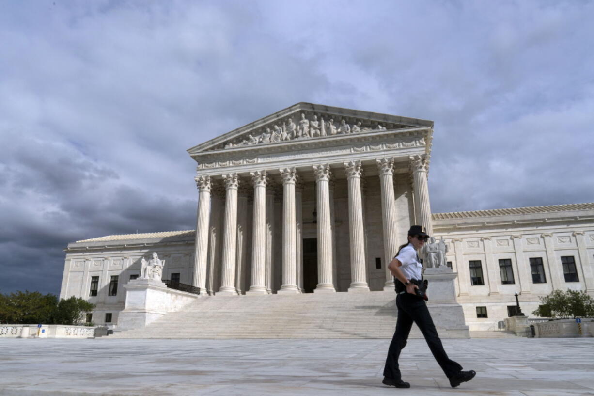 A police officer walks by during a voting rights rally, at the U.S. Supreme Court Thursday, Oct. 28, 2021, in Washington.