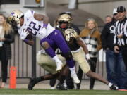 Washington running back Cameron Davis (22) is tackled by Colorado cornerback Mekhi Blackmon in the first half of an NCAA college football game Saturday, Nov. 20, 2021, in Boulder, Colo.