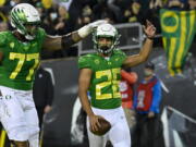 Oregon running back Travis Dye (26) celebrates his touchdown against Washington St with offensive lineman George Moore (77) during the first quarter of an NCAA college football game Saturday, Nov. 13, 2021, in Eugene, Ore.