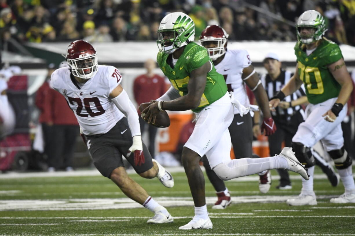 Oregon quarterback Anthony Brown (13) is pursued by Washington State defensive end Quinn Roff (20) during the third quarter of an NCAA college football game Saturday, Nov. 13, 2021, in Eugene, Ore.