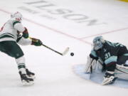 Minnesota Wild center Rem Pitlick, left, scores a goal on Seattle Kraken goaltender Philipp Grubauer (31) during the second period of an NHL hockey game Saturday, Nov. 13, 2021, in Seattle. The goal was Pitlick's first of two goals in the second period. (AP Photo/Ted S.