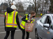 Seton Catholic High School students Cami Price, left, and Lara Carrion accept donations at a Drive & Drop food drive at Hudson's Bay High on Saturday. Price and Carrion were among a larger group of local National Honor Society students volunteering at the various drop off locations.