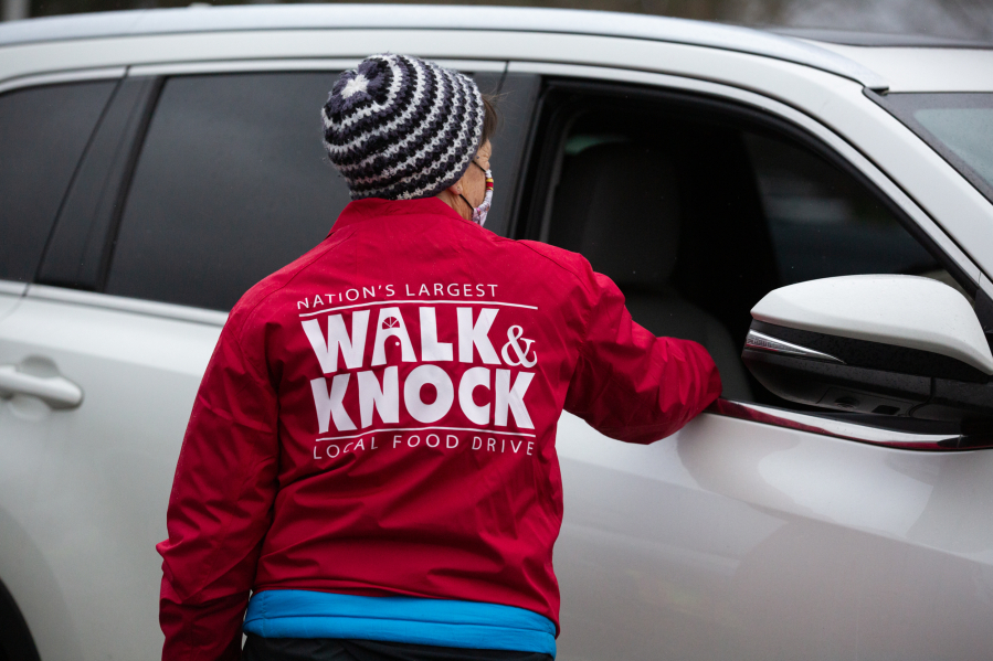 Janet Elliott, sector coordinator for Walk & Knock, greets a donor Dec. 4 at Hudson's Bay High School, which was a drop-off site for food donations as the Walk & Knock food drive became Drive & Drop for the second year because of the pandemic.