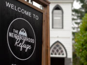 A sign, with a belltower in the background, welcomes guests to The Neighborhood Refuge in Ridgefield.