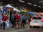 A long line of motorists drive through the second annual Caregivers Christmas, hosted by the nonprofit Loving Them Forward, at the Clark County Event Center at the Fairgrounds on Tuesday morning. The organization was able to quadruple its efforts this year, a sign of increased giving this holiday season.