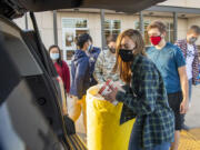 Seton Catholic junior Stefanie Valent-Musleh, front, and other students load Walk & Knock food donations. Last year, Seton Catholic wasn't able to participate in the event. "We're embracing it this year, and we're so excited to be a part of it," said Vice Principal Dan Chase while helping students load the donations into cars.